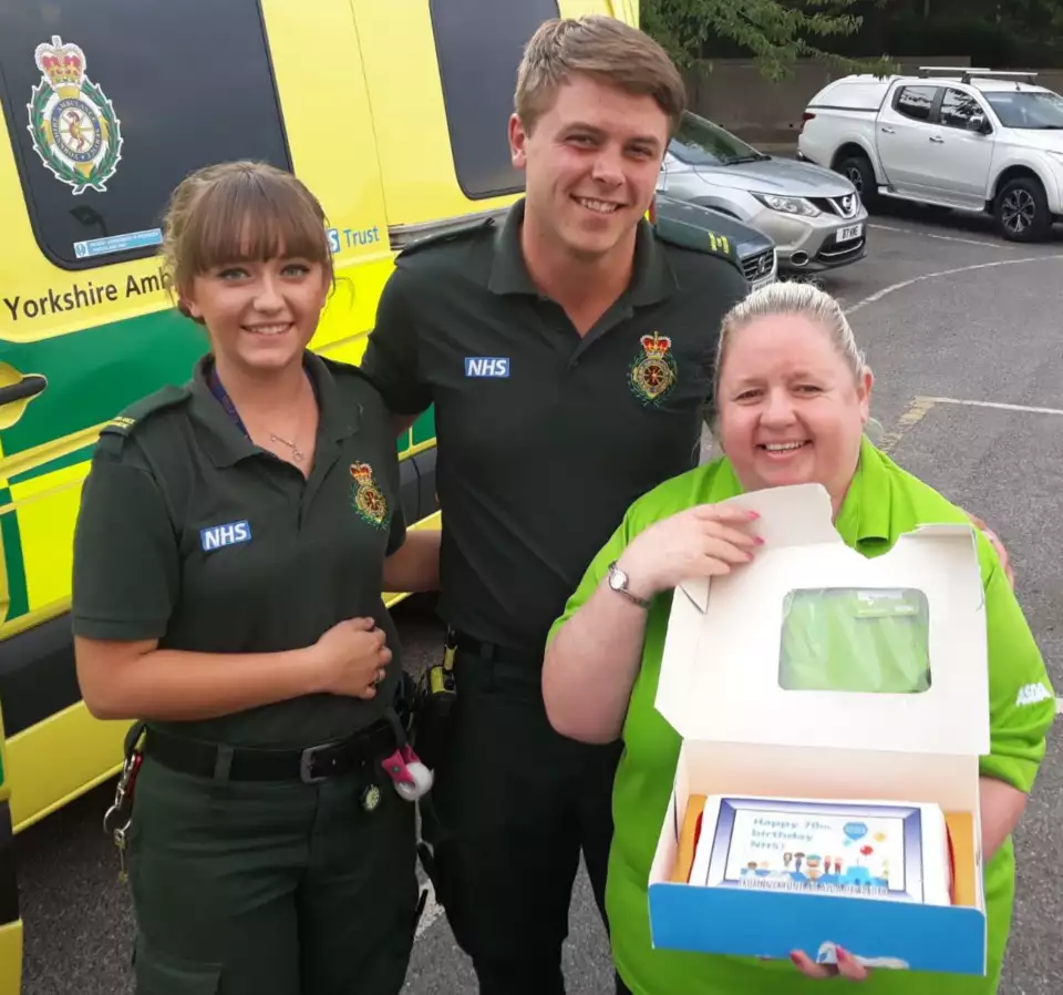 Asda Dewsbury community champion Sharon Kingswood with the NHS birthday cake at Yorkshire Ambulance Service
